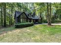 Striking exterior showcasing a home with dark siding, large windows, and a well-manicured lawn at 5217 West Oaks Dr, Fuquay Varina, NC 27526