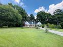 Beautiful home with a well-manicured lawn and mature trees in a serene, landscaped setting at 101 Creekside Dr, Selma, NC 27576