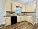 Functional kitchen with granite countertops, wood-look flooring, and bright, painted cabinets at 101 Creekside Dr, Selma, NC 27576