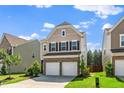 Charming two-story home featuring a two-car garage, brick accents, and a cozy front yard at 1022 Homecoming Way, Durham, NC 27703