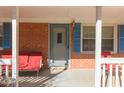 Inviting front porch with red seating and a brick facade, perfect for relaxing outdoors at 1186 Dick Holeman Rd, Timberlake, NC 27583