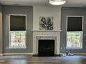 Cozy living room featuring a fireplace, two windows and hardwood floors at 121 Brentfield Loop, Morrisville, NC 27560
