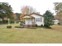 Attractive home featuring a covered porch, well-maintained lawn, and complemented by mature trees at 124 Jack Bennett Rd, Chapel Hill, NC 27517