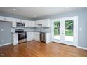 Bright kitchen features modern stainless steel appliances, white cabinetry and gorgeous wood flooring at 1344 Highland Dr, Wake Forest, NC 27587