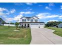 Beautiful two-story home with a three-car garage and a lush green lawn under a bright blue sky at 175 Steep Rock Dr, Willow Springs, NC 27592