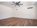 A well lit bedroom features wood flooring, a ceiling fan, and two bright windows at 205 Gentry St, Roxboro, NC 27573