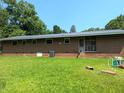 Back exterior of brick home with a metal roof and spacious yard at 2306 Cool Springs Rd, Sanford, NC 27330