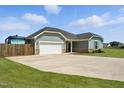 Single-story home with a two-car garage, long driveway, well-kept lawn and fenced in RV parking at 25 Harlow Ct, Fuquay Varina, NC 27526