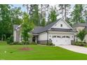 Beautiful home with stone and white siding, lush green lawn, and a tree in the front yard at 2511 Range Overlook Xing, Apex, NC 27523
