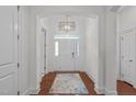Bright foyer with hardwood floors, a chandelier, and a clear view of the front door at 2511 Range Overlook Xing, Apex, NC 27523