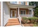 Inviting front porch with brick steps and white railings, leading to the front door of the home at 2613 Sweet Gum Dr, Hillsborough, NC 27278