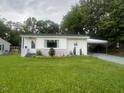 Single story home with nice grass and shrubs, with carport to the side at 331 E Lillington St, Angier, NC 27501