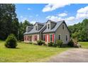 Charming home featuring red shutters, a well-manicured lawn, and a side patio area at 3573 Northern Estates Cir, Rocky Mount, NC 27804