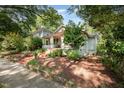 A charming home with a brick staircase, a cozy porch, and lush landscaping, blending seamlessly with its surroundings at 513 Cutler St, Raleigh, NC 27603