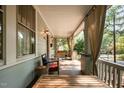 Inviting front porch featuring wood furniture, hanging curtains, and a relaxing ambiance for outdoor enjoyment at 513 Cutler St, Raleigh, NC 27603