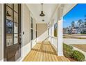Inviting front porch with wooden floors, white columns, and views of the surrounding neighborhood at 5148 Glen Creek Trl, Garner, NC 27529