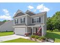 Charming two-story home boasting gray siding, black shutters, and a well-manicured lawn on a sunny day at 534 Lionheart Ln, Sanford, NC 27330