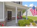 Inviting front porch featuring brick accents, a cozy seating area, and a decorative American flag at 534 Lionheart Ln, Sanford, NC 27330