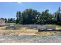 New home foundation of concrete blocks sits on a gravel lot with a tree line in the background at 55 Shoreline Dr, Lillington, NC 27546