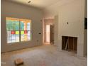 Unfinished living room area featuring a large window, door, and fireplace, ready for customization at 701 East St, Smithfield, NC 27577