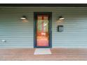Inviting front porch featuring a red-framed door, vintage sconces, and the house number 