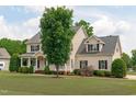 Beautiful two-story home showcasing a lush front lawn, black shutters, and a covered porch at 7217 Leando Dr, Willow Springs, NC 27592