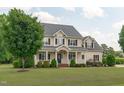 Charming two-story house featuring a well-maintained lawn, covered porch, and mature trees at 7217 Leando Dr, Willow Springs, NC 27592
