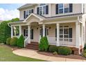 Inviting front porch with white columns and railings, leading to a charming home entrance at 7217 Leando Dr, Willow Springs, NC 27592