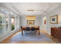Elegant dining room with tray ceilings, chandelier, and a large window with plantation shutters at 7529 Tynewind Dr, Wake Forest, NC 27587