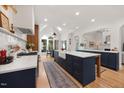 Bright, open kitchen with a large center island, farmhouse sink, and modern appliances at 7529 Tynewind Dr, Wake Forest, NC 27587
