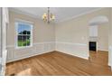 Elegant dining room with hardwood floors, chair rail molding, and a chandelier over a large window at 86 Woodall Farm Ln, Princeton, NC 27569