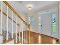 Bright foyer with hardwood floors, a staircase, and a view to the front door and outside at 86 Woodall Farm Ln, Princeton, NC 27569