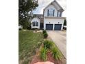 Well-maintained home featuring a two-car garage, a manicured lawn, and mature landscaping at 917 Widewaters Pkwy, Knightdale, NC 27545