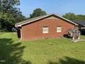 A sunny backyard features a well-kept lawn and an adorable playhouse, perfect for outdoor fun and relaxation at 1021 Delray St, Durham, NC 27713