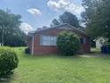 Quaint red brick home with blue shutters and a freshly cut lawn at 1021 Delray St, Durham, NC 27713