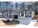 Contemporary home with gray siding, stone accents, and a two-car garage; a charming residence at 110 Mohave Dr, Louisburg, NC 27549
