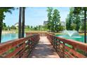 Scenic pond view with wooden pier, fountain, and lush greenery offering a tranquil escape in the community at 1205 Barreto Dr, Wendell, NC 27591