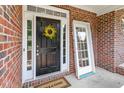 Classic black front door adorned with a cheerful yellow wreath and a new door at 1505 Poets Glade Dr, Apex, NC 27523