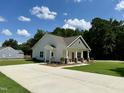 View of the home's exterior showcasing a long driveway and a well-maintained lawn at 172 W Old Rd, Lillington, NC 27546