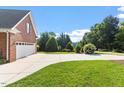Long driveway leading to a brick home, surrounded by lush greenery and well-manicured lawns at 175 Georgetown Woods Dr, Youngsville, NC 27596