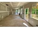 Unfinished living room area with drywall, windows, and a view to the outside porch at 177 Millwood Dr, Clayton, NC 27527
