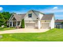 Beautiful two-story home featuring a three-car garage, well maintained lawn and inviting front porch at 20 Kola Nut, Smithfield, NC 27577