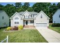 Charming two-story home with a well-manicured lawn, garden, and an attached two-car garage at 212 Mickleson Ridge Dr, Raleigh, NC 27603