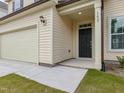 Inviting entrance featuring a black front door, adjacent garage, and manicured lawn at 239 Faith Avenue, Sanford, NC 27330