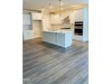 Bright kitchen showcasing stainless appliances, white cabinets, a center island, and modern backsplash at 2432 Nassau Trce, Fuquay Varina, NC 27526