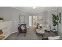 Living room with gray walls, carpet, ceiling fan, painting on wall, and view into bathroom at 2521 Friedland Pl # 303, Raleigh, NC 27617