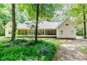 Rear view of home featuring a screened porch, nestled within a serene, wooded lot at 26 Shadymont Dr, Pittsboro, NC 27312