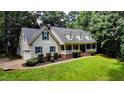 Beautiful home showcasing a long front porch, manicured landscaping, and classic design elements at 26 Shadymont Dr, Pittsboro, NC 27312