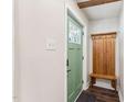 Inviting entryway featuring a green front door, a convenient coat rack with bench, and dark wood-look flooring at 309 E End Ave, Durham, NC 27703