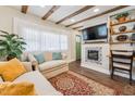 Comfortable living room with beamed ceiling, fireplace, large window, and a cozy seating arrangement with stylish decor at 309 E End Ave, Durham, NC 27703